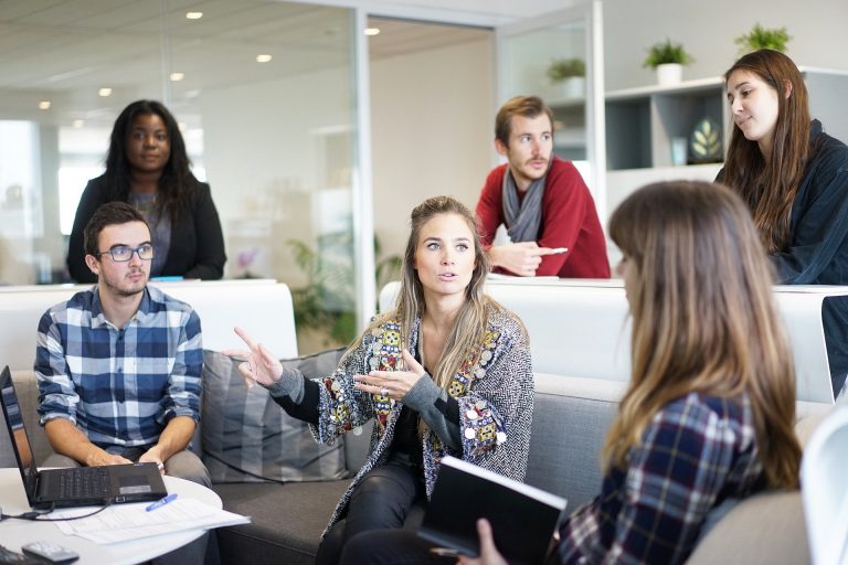 Team in a coaching session discussing learning and support methods, illustrating differences between coaching, mentoring, training, and counselling.
