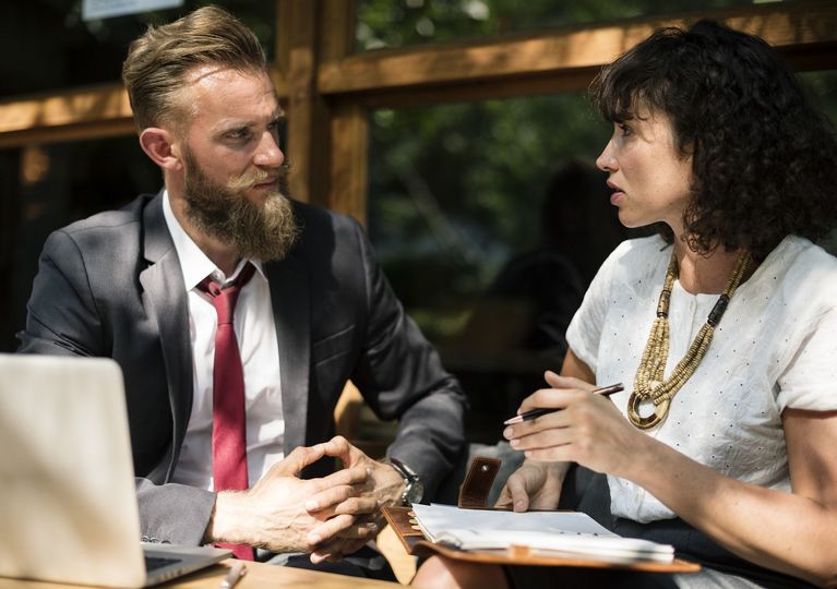 Two professionals in a serious one-on-one meeting, highlighting emotional intelligence and coaching presence.