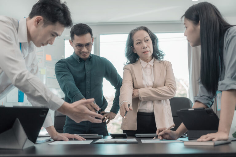 Manager giving clear direction to the sales team during a high-pressure discussion in a business meeting